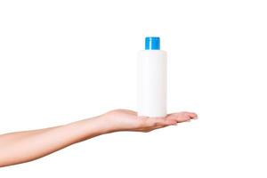 femmina mano Tenere crema bottiglia di lozione isolato. ragazza dare tubo cosmetico prodotti su bianca sfondo foto