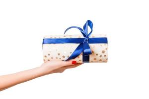 donna mani dare avvolto Natale o altro vacanza fatto a mano presente nel oro carta con blu nastro. isolato su bianca sfondo, superiore Visualizza. ringraziamento regalo scatola concetto foto