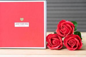 rosso Rose e a forma di cuore scatola su legna sfondo foto