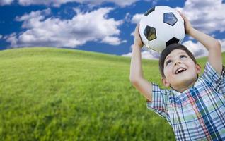 carino ragazzo con calcio palla nel parco foto