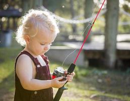 carino giovane ragazzo con pesca polo a il lago foto