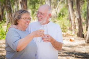 contento salutare anziano coppia con acqua bottiglie foto