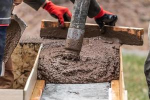 costruzione lavoratore livellamento bagnato cemento in legna inquadratura foto