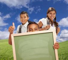 studenti con pollici su nel campo Tenere vuoto gesso tavola foto