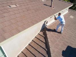 professionale pittore utilizzando un' spazzola per dipingere Casa fascia foto