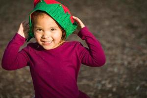 carino misto gara giovane bambino ragazza avendo divertimento indossare Natale cappello all'aperto foto