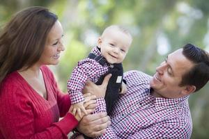 poco bambino ragazzo avendo divertimento con madre e padre all'aperto foto