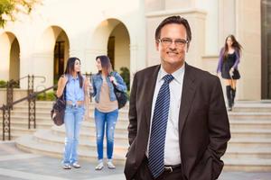 maschio adulto amministratore nel completo da uomo e cravatta a piedi su città universitaria foto