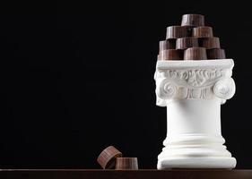 pila di bene artigiano cioccolatini impilati su bianca pilastro colonna foto