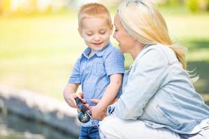 giovane caucasico madre e figlio avendo divertimento pesca a il lago foto