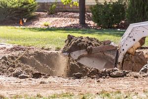 piccolo bulldozer scavando nel cortile per piscina installazione foto