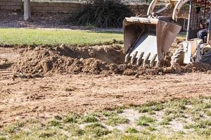 piccolo bulldozer scavando nel cortile per piscina installazione foto