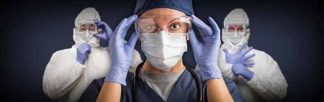 squadra di femmina e maschio medici o infermieri indossare protettivo medico viso maschere e occhiali bandiera foto