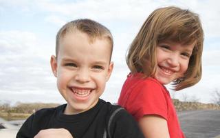Due bambini Sorridi per il telecamera foto