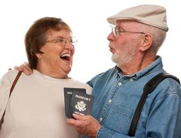 contento anziano coppia con passaporti e borse su bianca foto