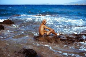 bello uomo su il marino roccioso riva foto