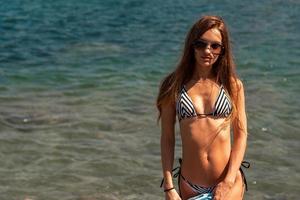 carino giovane ragazza a il blu mare foto