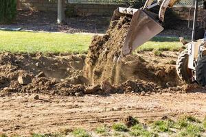 piccolo bulldozer scavando nel cortile per piscina installazione foto