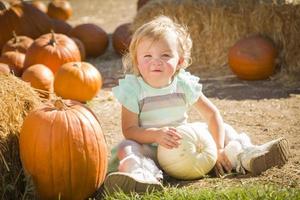 adorabile bambino ragazza Tenere un' zucca a il zucca toppa foto