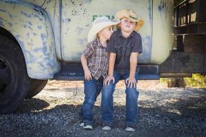 Due giovane ragazzi indossare cowboy cappelli pendente contro antico camion foto