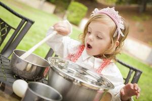 adorabile poco ragazza giocando capocuoco cucinando foto