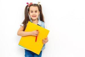 contento dolce poco scuola ragazza trasporto cartella zaino e libri sorridente nel formazione scolastica e indietro per scuola concetto isolato su bianca sfondo foto