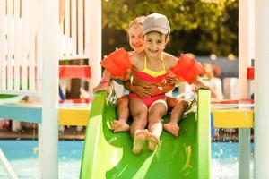 bambini su acqua diapositiva a Parco acquatico. estate vacanza. foto