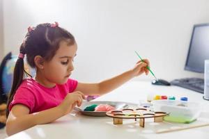 poco ragazza pittura nel sua asilo a casa foto