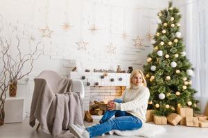 giovane donna di un' camino su caldo Natale sera foto