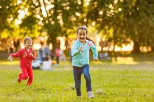 adorabile poco ragazze avendo divertimento giocando all'aperto su estate giorno foto