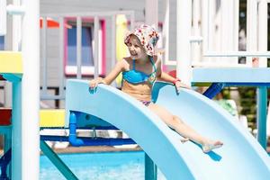 bambini su acqua diapositiva a Parco acquatico. estate vacanza. foto