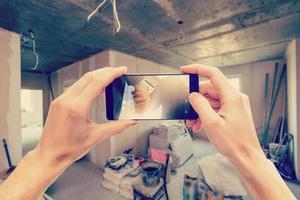 Due mani Tenere un' mobile smartphone e prendere un' immagine nel un' moderno lusso vivente camera foto