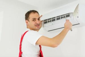 maschio tecnico pulizia aria condizionatore in casa foto