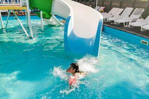 poco ragazza giocando nel all'aperto nuoto piscina salto in acqua su estate vacanza su tropicale spiaggia isola. bambino apprendimento per nuotare nel all'aperto piscina di lusso ricorrere. foto