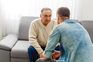 adulto figlio parlando per depresso padre a casa foto