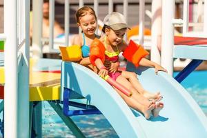 Due poco bambini giocando nel il nuoto piscina foto