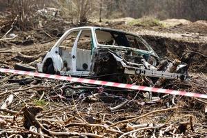 rotto auto nel un' cumulo di rifiuti nel il campo foto