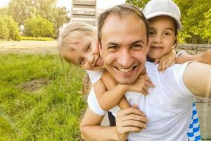 bellissimo ricordi. famiglia di quattro assunzione autoscatto foto su smartphone nel luce del sole sorridente contento