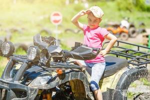 poco ragazza equitazione atv quadrilatero bicicletta nel gara traccia foto