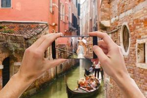 assunzione immagini su mobile inteligente Telefono nel gondola su canale Grande con classico vecchio Casa nel il sfondo, Venezia, Italia foto