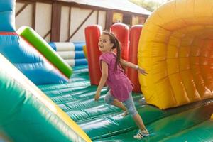 un' allegro bambino giochi nel un gonfiabile castello foto