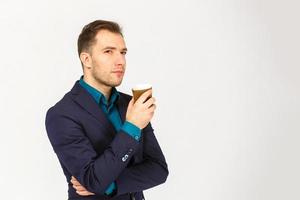 ritratto di elegante bello lieta delizioso grave attraente sognante ricco elegante di classe uomo odorare il aroma di fresco amaro caffè isolato su grigio sfondo copia-spazio foto