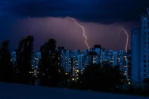 temporale con enorme fulmine al di sopra di notte città foto