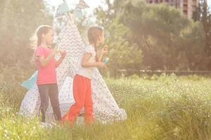 adorabile poco ragazze avendo divertimento giocando all'aperto su estate giorno foto