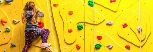 poco ragazza su arrampicata nel divertimento centro. foto