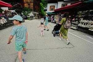 madre con bambino carrozza e bambini a piedi nel giusto a Hallstatt, Austria. foto
