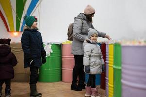 contento poco bambini con madre nel un' caramella memorizzare sceglie dolci, marmellata caramelle, mette loro nel un' carta Borsa. foto