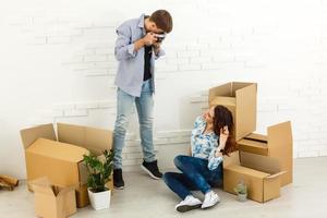 sorridente coppia pendente su scatole nel nuovo casa foto