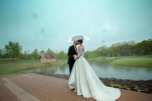 fascino giovane si è sposato coppia baci sotto il ombrello foto
