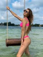 bellissima giovane donna sta vicino il swing a il mare foto